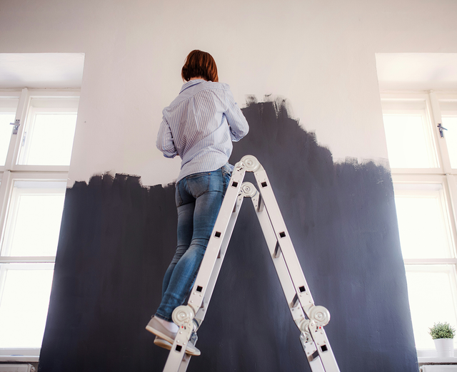 Person painting room of house